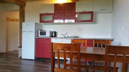 a kitchen with a wooden table and a white refrigerator at Penzion Filoun in Plavy