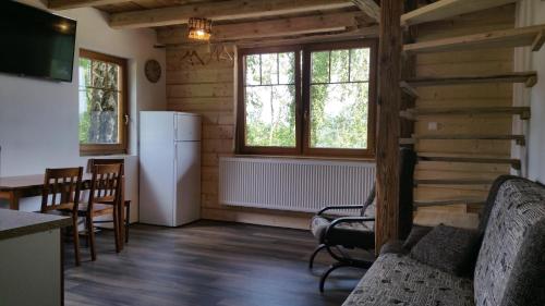 a living room with a refrigerator and a table and chairs at Penzion Filoun in Plavy