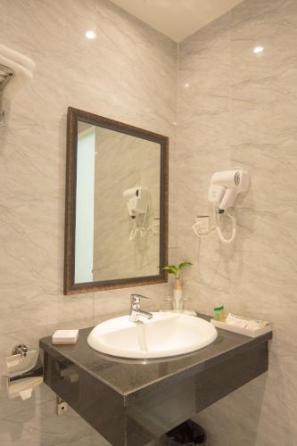 a bathroom with a sink and a mirror at Vy House in Hanoi