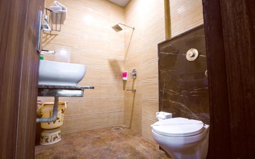 Un baño pequeño con inodoro y lavabo. en Hotel Shivaay Grand, en Amritsar