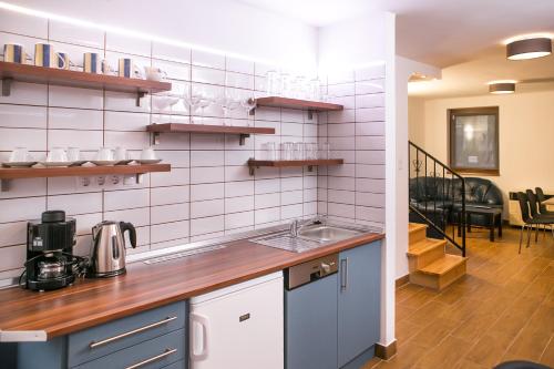 cocina con paredes de azulejos blancos y encimera en Starlight Apartment, en Mezőkövesd