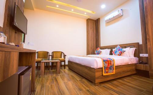 a hotel room with a bed and a flat screen tv at Hotel Shivaay Grand in Amritsar