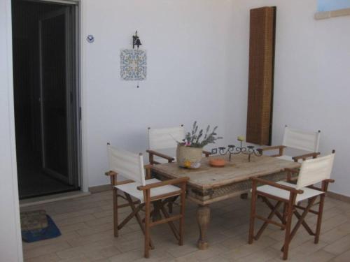einen Holztisch und Stühle in einem Zimmer in der Unterkunft Appartamento Perla Del Salento Porto Cesareo in Porto Cesareo