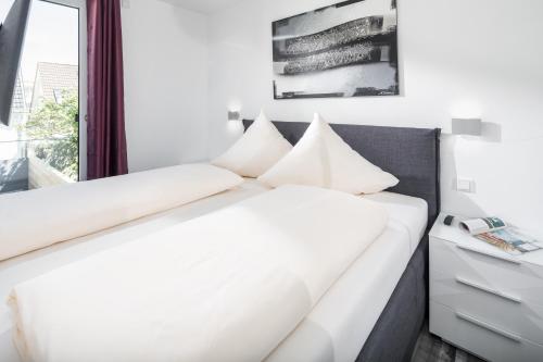 Postel nebo postele na pokoji v ubytování MeerZeit 8 - Norderney - Winterstraße 19