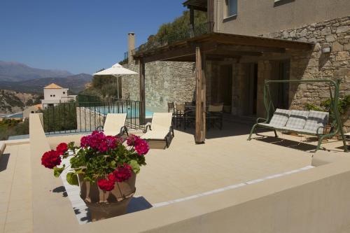 a patio with flowers in a pot on a house at Istron Luxury Villas in Istron