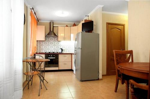 モスクワにあるBarclay Apartmentのキッチン(冷蔵庫、テーブル、椅子付)