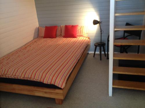 ラドルフツェル・アム・ボーデンゼーにあるFerienhaus am Litzelbergのベッドルーム1室(赤い枕とはしご付きのベッド1台付)