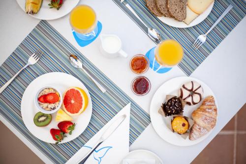 a table with plates of breakfast foods and glasses of orange juice at Grupotel Taurus Park in Playa de Palma