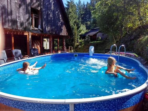 two children are swimming in a swimming pool at Penzion Filoun in Plavy