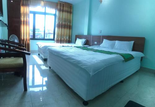 a bedroom with two beds and a window at Ruby Hostel Hà Giang in Ha Giang