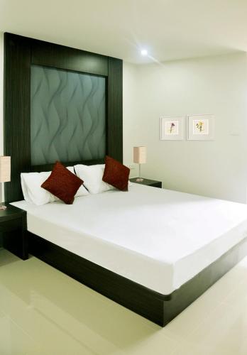 a bedroom with a large white bed with red pillows at DB Plus 3 in Bangkok