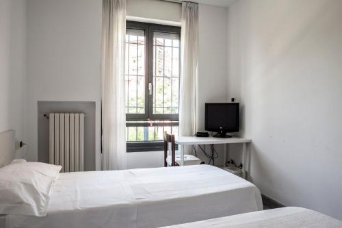 Bed & Breakfast Cesarina في بولونيا: غرفة نوم بسريرين وتلفزيون ونافذة