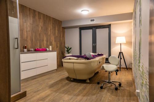 a bathroom with a tub and a chair and a desk at Hotel Oskar Business & Spa in Puławy