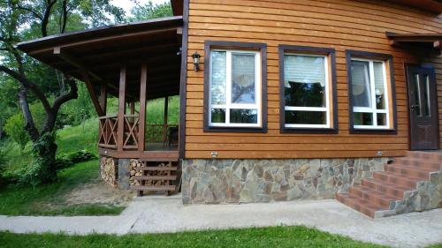 a cabin with a porch and a balcony at Country House Kosiv in Kosiv