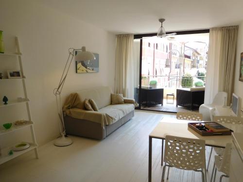 ein Wohnzimmer mit einem Sofa und einem Tisch in der Unterkunft Appartamento Tilatti in Grado