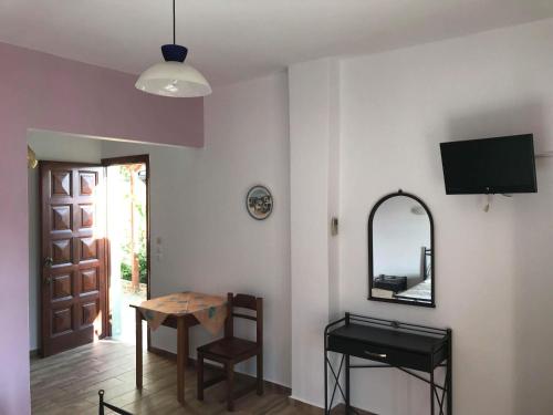 a room with a table and a mirror and a door at Elina Apartments in Batsi