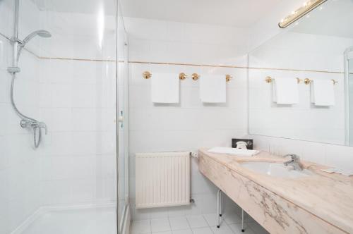La salle de bains blanche est pourvue d'un lavabo et d'une douche. dans l'établissement Gästehaus Fertschey, à Velden am Wörther See