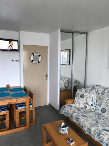 un salon avec un canapé et une table dans l'établissement Les cigales de la mer Place de la libération, au Grau-du-Roi