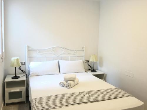 1 dormitorio con 1 cama blanca y 2 mesitas de noche en Aiguaneu Sa Carbonera, en Blanes