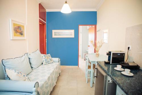 a living room with a couch and a blue wall at Maria Studios in Poros