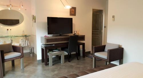 a living room with a television and two chairs at Private Hôtel - Adults Only in Porto-Vecchio