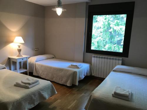 a room with two beds and a window at Apartamento Balcon De Jaca I in Jaca