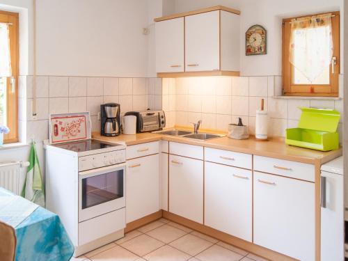 a kitchen with white cabinets and a sink at Ferienwohnung über den Dächern von Dresden in Dresden