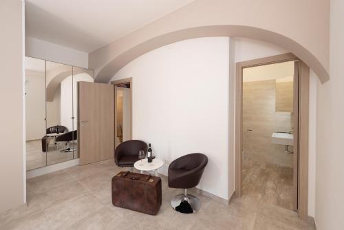 サレルノにあるRoof Gardenの椅子2脚、テーブル1台、鏡1台が備わる客室です。