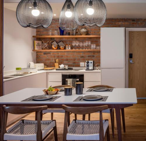 a kitchen with a table and chairs and two lights at Vineyard Hotel in Cape Town