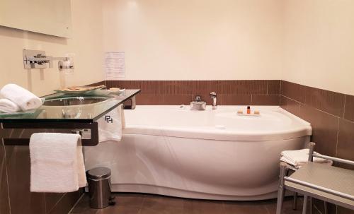 a bathroom with a white tub and a sink at Private Hôtel - Adults Only in Porto-Vecchio