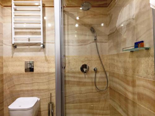 a bathroom with a shower with a toilet at Hotel Golden Tulip Varna in Varna City