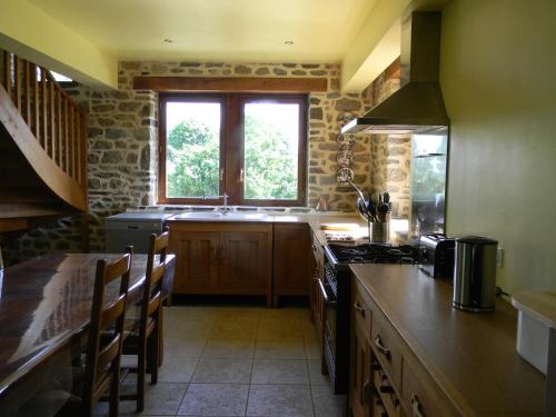 a kitchen with a counter and a sink and a window at La Boucharderie in Val Couesnon