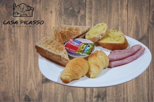 een bord eten met worstbrood en toast bij Happio Near Chabad House in Bangkok