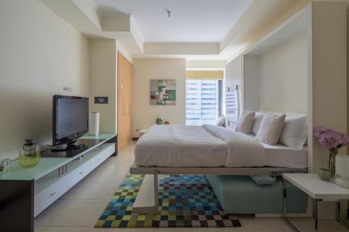 a bedroom with a large bed and a television at Frank Porter - Goldcrest Views in Dubai