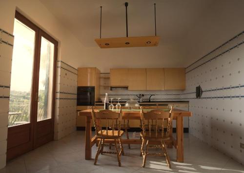 cocina con mesa de madera y sillas en Villa Fraele, en Acireale