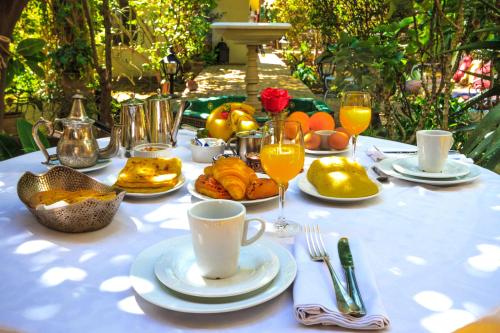 a table with a white table cloth with food and drinks at Riad El Arsat & Spa in Marrakech