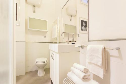 bagno bianco con lavandino e servizi igienici di ROMAC Condotti with 3 bedrooms near the Spanish Steps a Roma