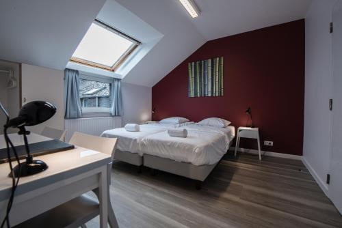 a bedroom with a large bed with a red wall at Auberge des 3 Fontaines in Brussels