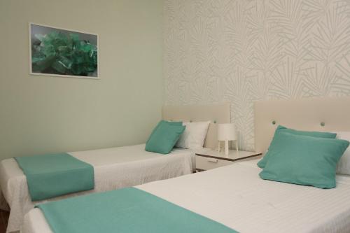 2 camas en una habitación con verde y blanco en Apartamentos Halley, en Puerto Rico de Gran Canaria