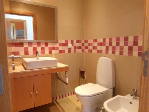 a bathroom with a sink and a toilet at Casa das Dunas Soltroia in Troia