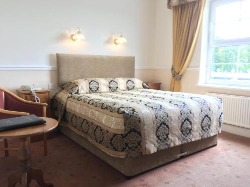 a hotel room with a large bed and a large window at Beggars Reach Hotel in Pembroke Dock