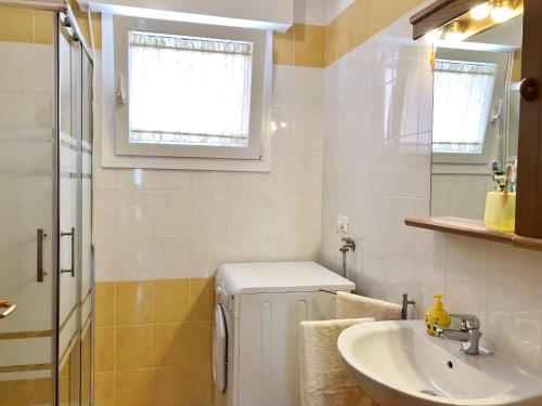 a bathroom with a sink and a washing machine at Casa Pola in Grado