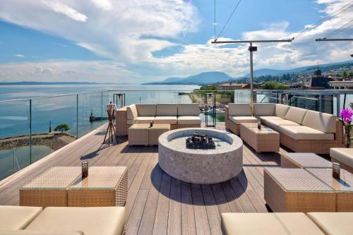 a patio with couches and a fire pit on a deck at Hotel Beaulac in Neuchâtel