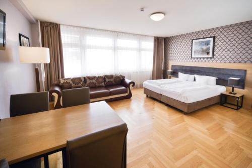 AMC Apartments Ku'damm & Bundesallee في برلين: غرفة نوم بسرير واريكة وطاولة