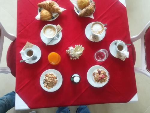 a red table with breakfast foods and coffee on it at Villa Marini Trevisan in Aviano