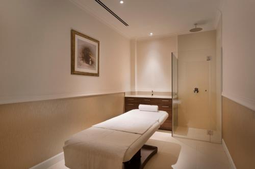 a small room with a bed and a shower at Herbert Samuel Jerusalem in Jerusalem