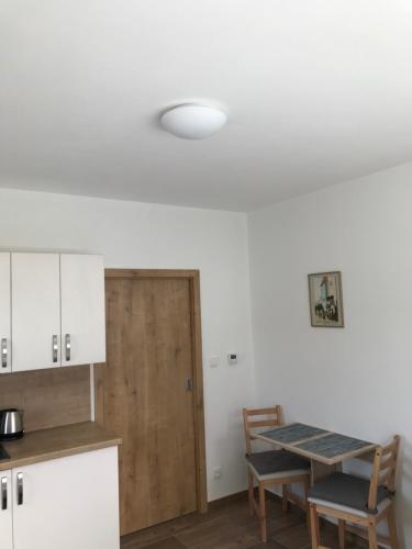 a kitchen with a table and a wooden door at Pension SALMA in Český Krumlov