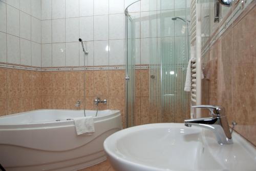 y baño con bañera, lavamanos y ducha. en König Hotel, en Nagykanizsa