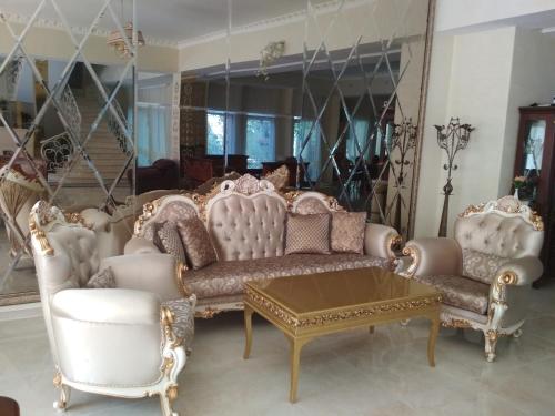 a living room with white furniture and a mirror at Hotel Elita in Odesa