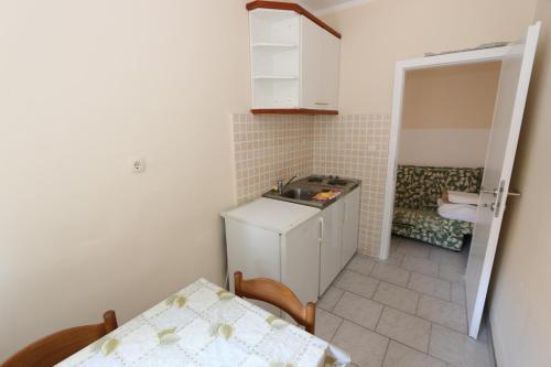 a small kitchen with a sink and a table at Apartmani Aron in Novalja